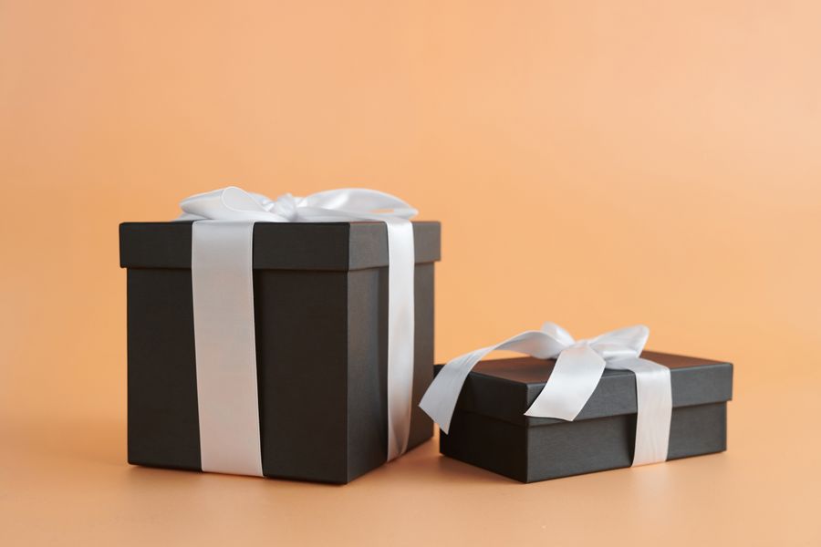 Two elegantly wrapped gift boxes with ribbons representing a custom phone cover gift